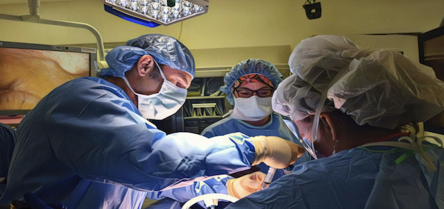 Dr. Robert Moore performing advanced urogynecologic surgery with a surgical team in the operating room 